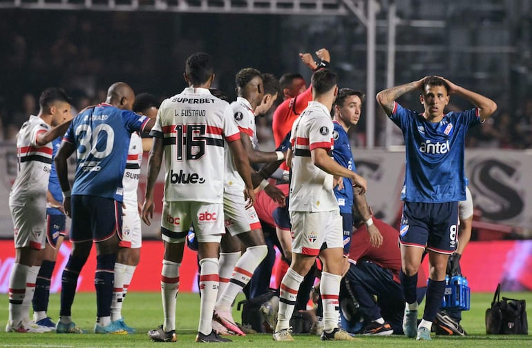 Juan Izquierdo, jugador de Nacional, es asistido por los médicos tras desplomarse en el campo de juego en pleno partido frente a Sao Paulo por los octavos de final de la Copa Libertadores 2024 en el estadio Morumbí, en Sao Paulo, Brasil.