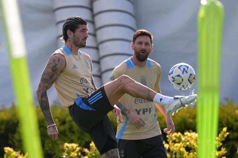 Argentina's midfielder #07 Rodrigo De Paul kicks the ball next to Argentina's forward #10 Lionel Messi during a training session ahead of the 2026 FIFA World Cup qualifier football match against Peru, in Ezeiza, Buenos Aires province,  on November 18, 2024. (Photo by JUAN MABROMATA / AFP)