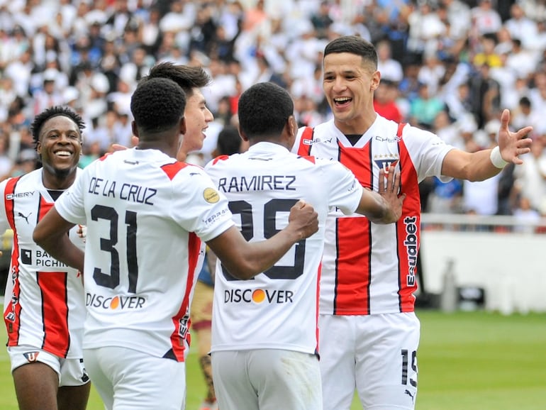 El paraguayo Alex Arce (d), futbolista de la Liga de Quito, festeja un gol en el partido frente al Deportivo Cuenca por la última fecha de la Segunda Fase de la LigaPro de Ecuador en el estadio Rodrigo Paz Delgado, en Quito.