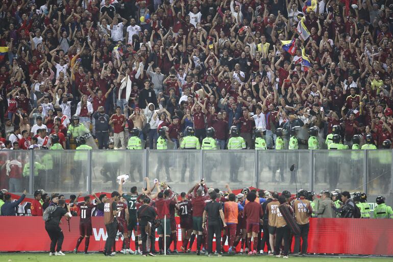 Jugadores de Venezuela celebran con los hinchas hoy, al final de un partido de las eliminatorias ante Perú para la Copa Mundo de Fútbol de 2026 en el estadio Nacional en Lima (Perú).