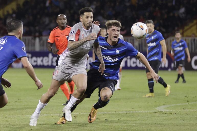 Renzo Malanca (d) de Huachipato disputa el balón con José Sosa (c) de Estudiantes este miércoles, en un partido de la fase de grupos de la Copa Libertadores entre Huachipato y Estudiantes en el estadio Huachipato en Talcahuano (Chile).