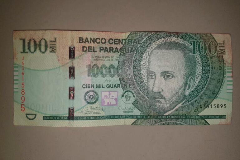 Un billete de 100.000 guaraníes con tinta roja, robado en el asalto al cajero automático del banco Sudameris.