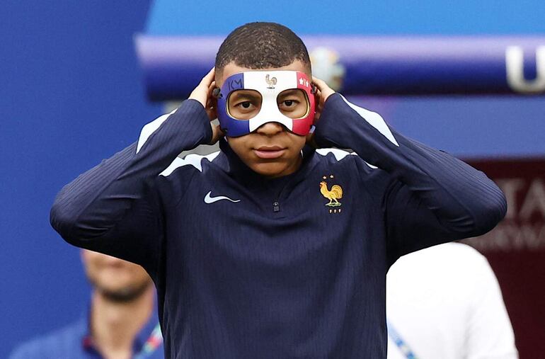 TOPSHOT - France's forward #10 Kylian Mbappe wears a face mask as he takes part in a MD-1 training session at the Leipzig Stadium in Leipzig on June 20, 2024, on the eve of their UEFA Euro 2024 Group D football match against Netherlands. (Photo by FRANCK FIFE / AFP)