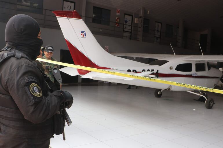 Un policía resguarda una avioneta confiscada durante un operativo en un hangar, este martes en Santa Cruz (Bolivia). 