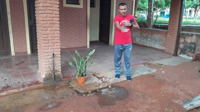 El director de la escuela San Francisco de San Antonio, Richard Ocampos, muestra el líquido que sale del pozo ciego que despide un desagradable olor.