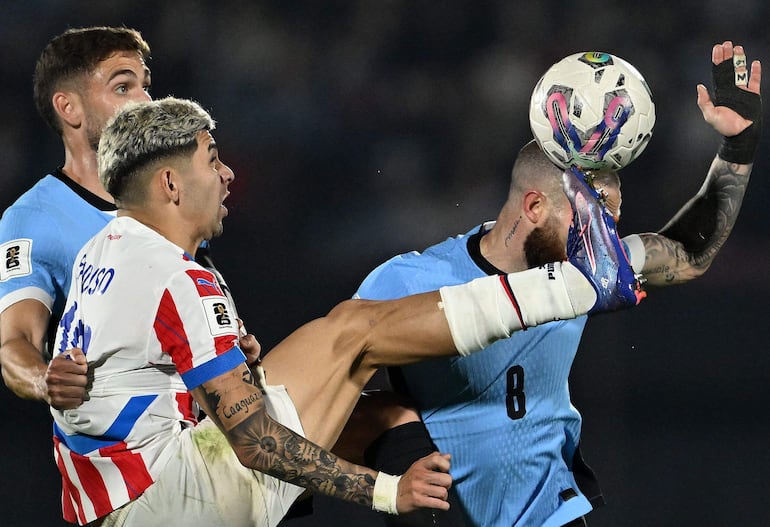 TOPSHOT - Paraguay's forward Julio Enciso (L) and Uruguay's midfielder Nahitan Nandez fight for the ball during the 2026 FIFA World Cup South American qualifiers football match between Uruguay and Paraguay at the Centenario stadium in Montevideo, on September 6, 2024. (Photo by Eitan ABRAMOVICH / AFP)