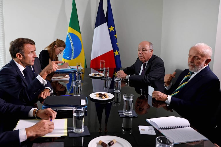 El presidente francés Emmanuel Macron (i) conversa con el mandatario de Brasil, Luiz Inacio Lula da Silva (d).