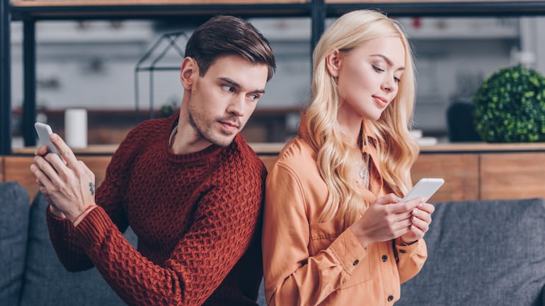 Hombre controlando el celular de su pareja