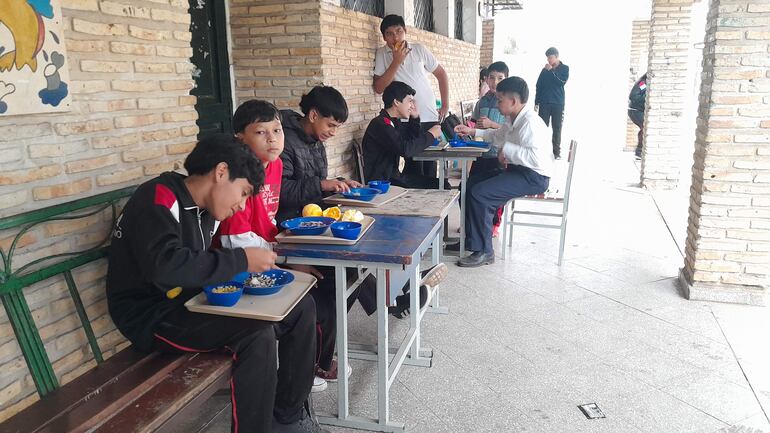 Alumnos de San Antonio reciben almuerzo de la empresa Comepar y comen sobre sus regazos, debido a que cuentan con comedor.