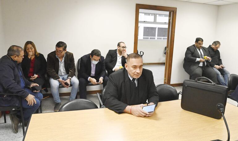 El fiscal Alcides Corvalan (en la mesa), durante la audiencia preliminar, esta mañana. Atrás, los acusados: Rubén Roussillón (i), Carmen Corina Alonso, Ricardo Núñez, José Ortiz y Omar Mongelos. A la derecha, junto a la pared, Álvaro Wasmosy.