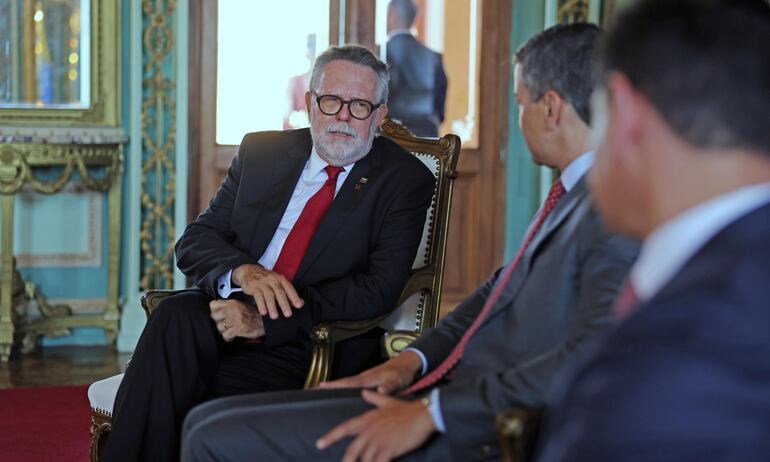 El nuevo embajador de Venezuela en Paraguay, Ricardo Capella (izq.) conversa con el presidente Santiago Peña (c). Fue ayer en Palacio de López.