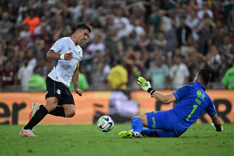 Luis Suárez  elude la salida del arquero Fabio, de Fluminense, antes de anotar un gol para Gremio.