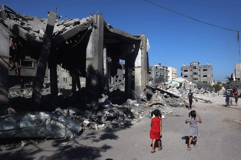 Varias personas caminan frente a una mezquita destruida por un bombardeo israelí, este miércoles en el campo de refugiados de Bureij, en la zona central de la Franja de Gaza.