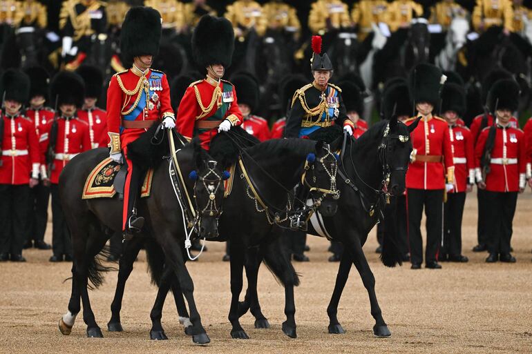 Primera de la izquierda, la princesa Ana cabalga durante el desfile "Trooping the Colour", en homenaje a su hermano Carlos III. A su lado, el príncipe Guillermo, y el príncipe Eduardo. 