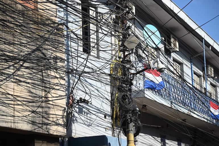 Banderas paraguayas adornan algunos edificios, pero son cubiertas por la maraña de cables, en el centro de Asunción.