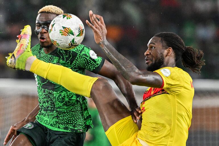 TOPSHOT - Angola's defender #6 Kialonda Gaspar (R) fights for the ball with Nigeria's forward #9 Victor Osimhen during the Africa Cup of Nations (CAN) 2024 quarter-final football match between Nigeria and Angola at the Felix Houphouet-Boigny Stadium in Abidjan on February 2, 2024. (Photo by Issouf SANOGO / AFP)