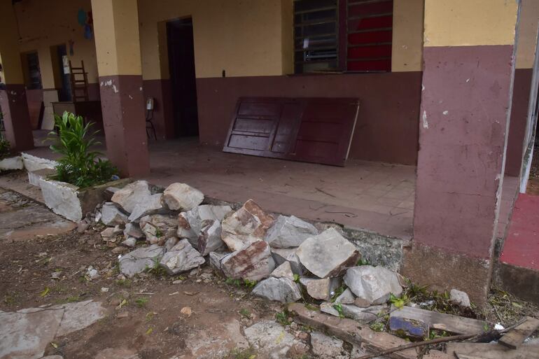 Un montón de piedras de gran tamaño acumuladas en la galería de primaria. En el fondo, una puerta deteriorada descansa en la escuela Blas Garay.