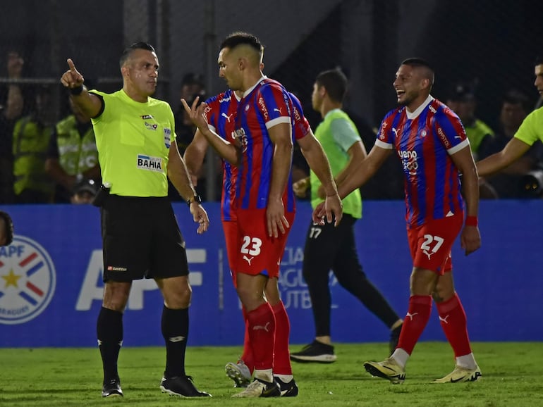 Alfio Oviedo (d), jugador de Cerro Porteño, conversa con el árbitro Carlos Paul Benítez durante el superclásico del fútbol paraguayo ante Olimpia en el torneo Apertura 2024 en el estadio Defensores del Chaco, en Asunción.