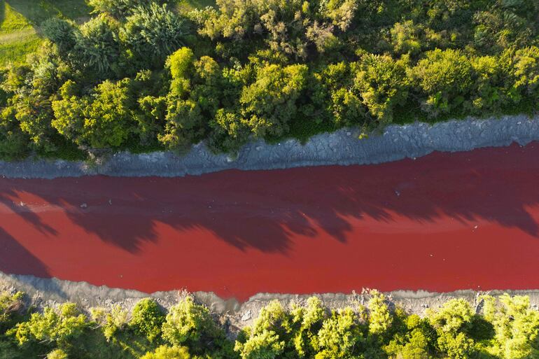 Esta vista aérea muestra un inusual color rojizo en el Canal Sarandí, que se filtra en el Río de la Plata en Sarandí, Avellaneda, en las afueras de Buenos Aires, el 6 de febrero de 2025.
