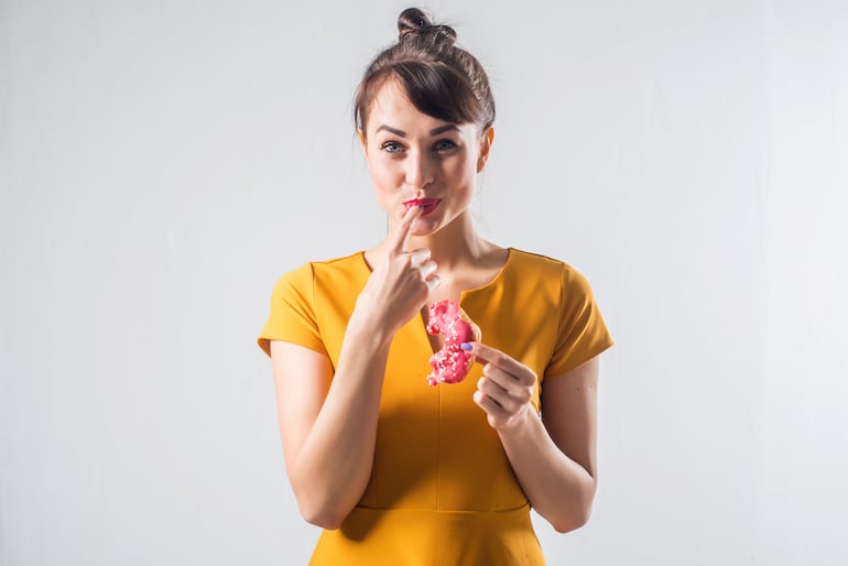 Mujer comiendo una masa dulce.