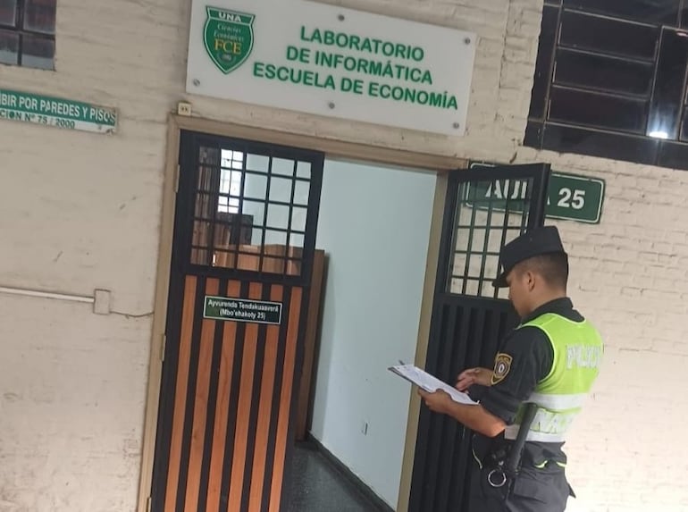 Un oficial de la policía toma notas del incidente en el aula de informática de la UNA.