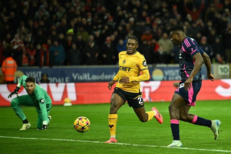 Nottingham Forest's Nigerian striker #09 Taiwo Awoniyi (R) scores their late third goal during the English Premier League football match between Wolverhampton Wanderers and Nottingham Forest at the Molineux stadium in Wolverhampton, central England on January 6, 2025. (Photo by Ben STANSALL / AFP) / RESTRICTED TO EDITORIAL USE. No use with unauthorized audio, video, data, fixture lists, club/league logos or 'live' services. Online in-match use limited to 120 images. An additional 40 images may be used in extra time. No video emulation. Social media in-match use limited to 120 images. An additional 40 images may be used in extra time. No use in betting publications, games or single club/league/player publications. / 