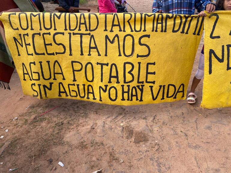 Cartel: COMUNIDAD TARUMANDIMI NECESITAMOS AGUA POTABLE, SIN AGUA NO HAY VIDA.