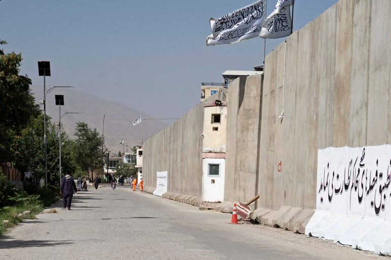 Hombres afganos caminan cerca del lugar un día después de que un atacante suicida detonara explosivos frente a la Dirección General de Vigilancia y Seguimiento de Decretos y Directivas, en Kabul, el 3 de septiembre de 2024. Un atacante suicida detonó explosivos en la capital afgana en septiembre 2, dijo la policía, matando a seis personas e hiriendo a 13 más.