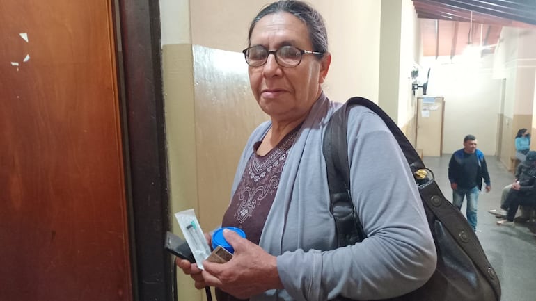 Petrona Sosa, al igual que otros pacientes, aguarda entregar su orden y con la jeringa para laboratorio.