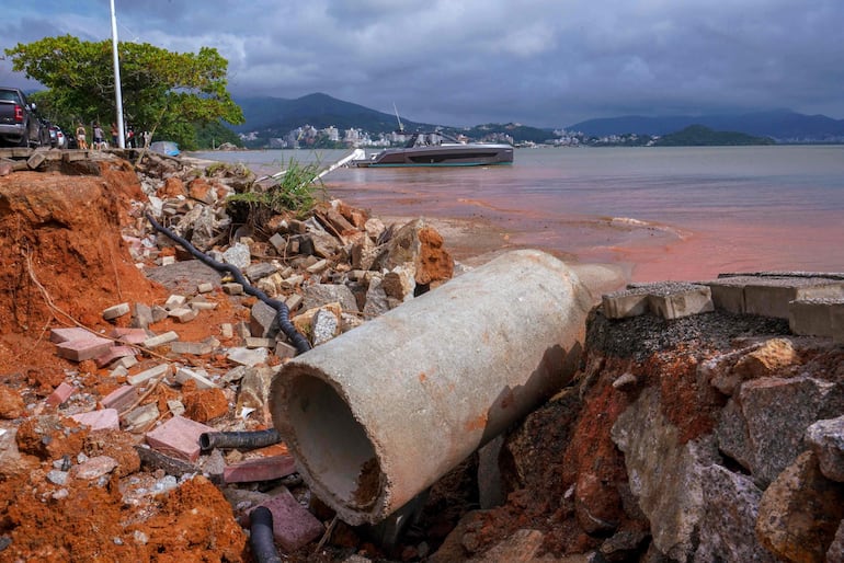 Un barco flota en la orilla junto a una acera, dañada por las fuertes lluvias en el barrio de Cacupé en Florianópolis, estado de Santa Catarina, Brasil. 