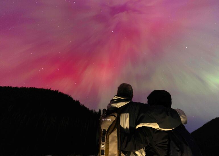 Una pareja observa la aurora borealis, o luces del norte, en Manning Park, Canadá.