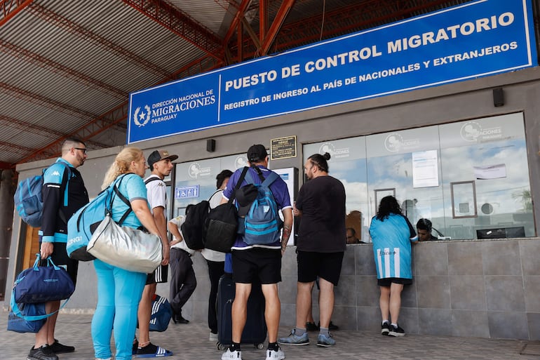 Hinchas de Racing se registran en un puesto de control migratorio.