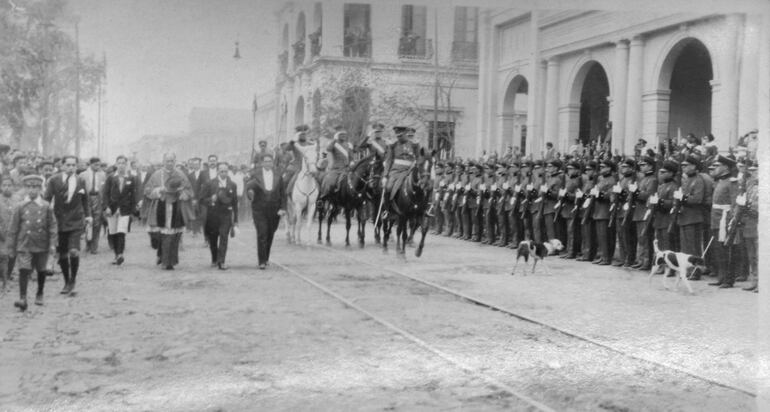 El presidente Eligio Ayala caminando desde la Catedral hasta el Palacio de López en 1924. Dos perros acompañan a sus escoltas. Colección Herib Caballero.