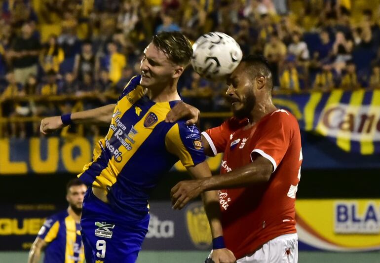 El delantero argentino del “Auriazul” Paul Charpentier va a la disputa aérea con el zaguero central tricolor Ismael Benegas.