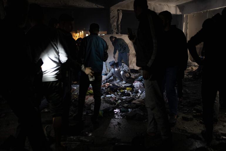 Varias personas inspeccionan el sitio del bombardeo israelí en la escuela de la UNRWA, este domingo.