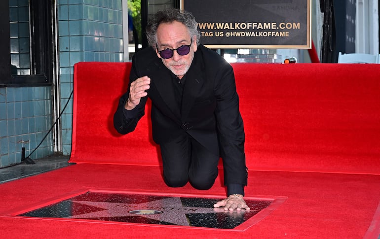 El director estadounidense Tim Burton posa con su estrella del Paseo de la Fama de Hollywood durante una ceremonia en Hollywood, California, el 3 de septiembre de 2024.