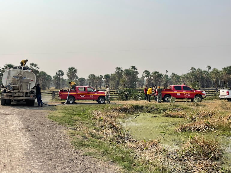 Las camionetas recargan agua desde el camiòn cisterna, para luego llegar hasta donde se localiza el fuego, en busca de combatirlo. 