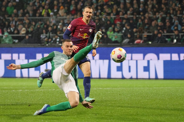 Marvin Ducksch, del Werder Bremen, remata el balón ante la presencia de un jugador del Leipzig.