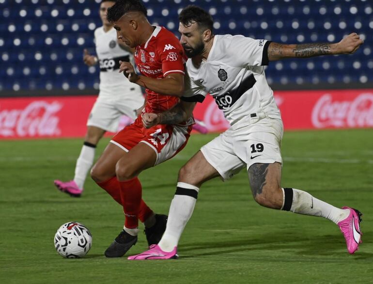 Lucas Pratto, jugador de Olimpia, pelea el balón con Alexis Rodas, de General Caballero JLM.