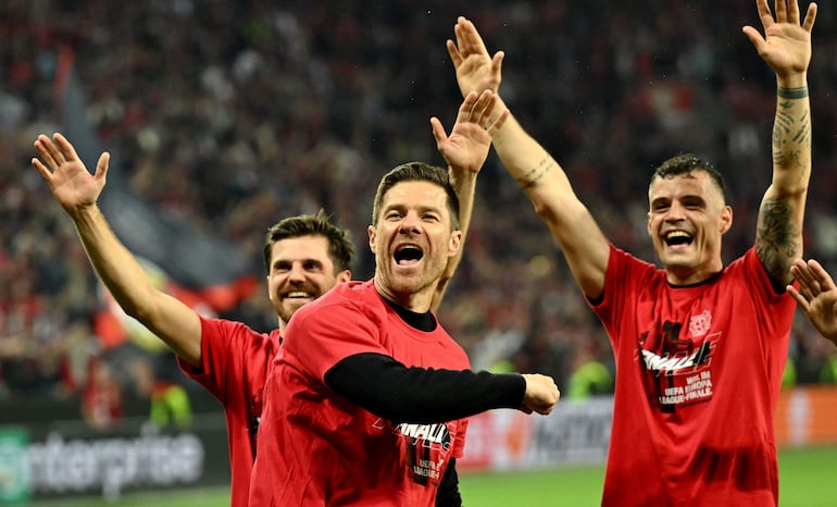 Bayer Leverkusen's Spanish head coach Xabi Alonso (C) celebrates after the UEFA Europa League semi final second leg football match between Bayer Leverkusen and ASC Roma in Leverkusen, on May 9, 2024. (Photo by INA FASSBENDER / AFP)