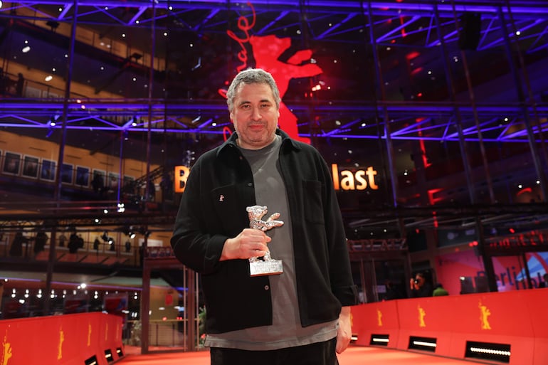 Radu Jude posa frente al Berlinale Palast con su Oso de Plata al Mejor Guion.