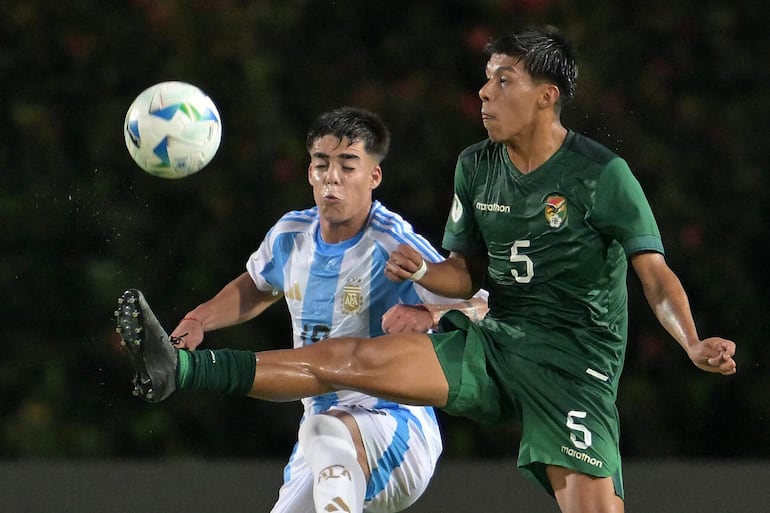 Argentina's defender #18 Teo Rodriguez and Bolivia's defender #05 Jhonny Cuiza fight for the ball during the 2025 South American U-20 football championship match between Argentina and Bolivia at the Misael Delgado stadium in Valencia, Carabobo state, Venezuela on January 28, 2025. (Photo by JUAN BARRETO / AFP)