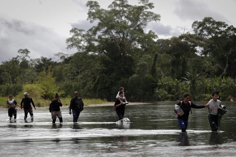 Migrantes cruzan el río Tuquesa luego de atravesar la selva del Darién, este jueves en el Darien (Panamá). El director de la Aecid, Antón Leis, visitó esta semana el poblado al que llegan a diario cientos de migrantes tras atravesar durante días la peligrosa selva del Darién, la frontera natural entre Colombia y Panamá.