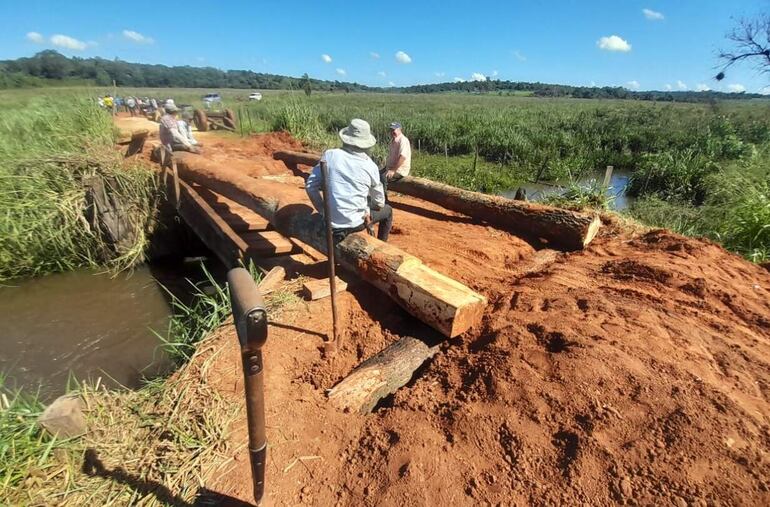 Pobladores de la compañía Kuarahy Rese reparando el puente sobre el arroyo Cueva Kua-i.