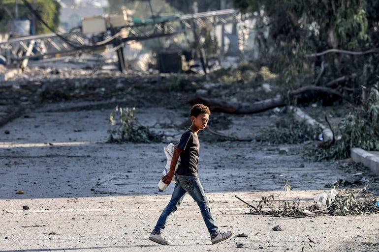 Un niño camina en una zona dañada por bombardeos israelíes en la Ciudad de Gaza, este jueves.