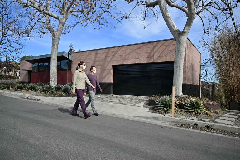 El arquitecto estadounidense Michael Kovac camina junto a su esposa, Karina Maher, fuera de su hogar, que sobrevivió al incendio de Palisades gracias a las características resistentes al fuego utilizadas en su construcción, en el barrio de Pacific Palisades en Los Ángeles.