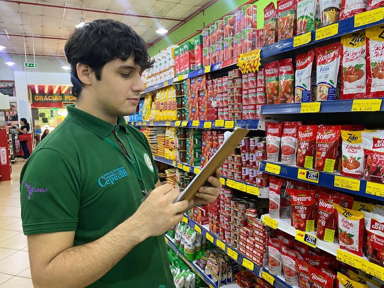 Un alumno de la Universidad Nacional del Este en la tarea de verificación de precios de los productos de la canasta básica.