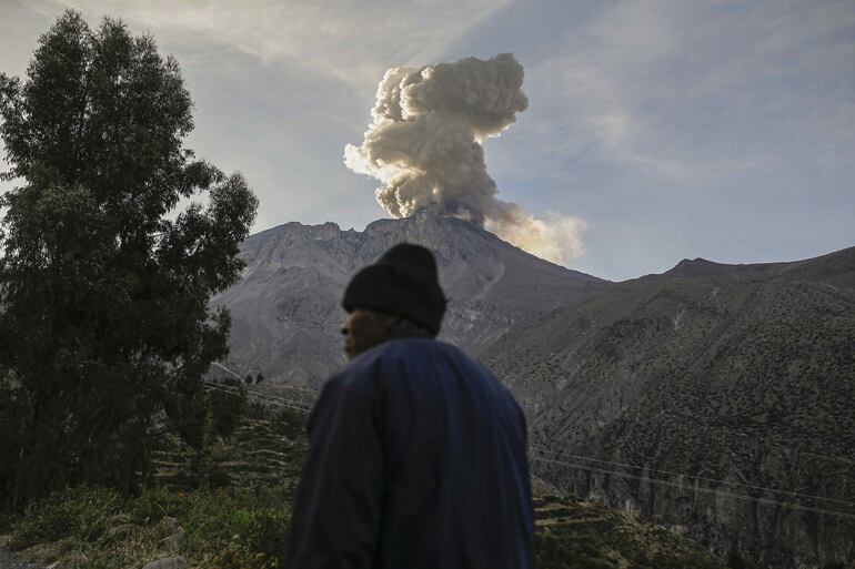 Una persona camina hoy con el volcán Ubinas de fondo, en Moquegua (Perú). El Consejo de Ministros de Perú aprobó este miércoles declarar en estado de emergencia por 60 días a los distritos cercanos al volcán Ubinas (sur), que se encuentra desde el martes en etapa eruptiva y que ha llegado a expulsar columnas de humo y cenizas de más de 5 kilómetros de altura. EFE/Stringer