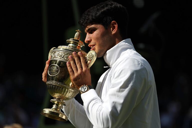 El tenista español Carlos Alcaraz celebra la victoria sobre Novak Djokovic y la conquista de Wimbledon 2024 en el All England Lawn Tennis and Croquet Club, en Wimbledon, Londres.