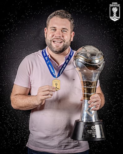 El entrenador Ariel Galeano posando con el trofeo y la medalla de campeón de la Copa Paraguay.